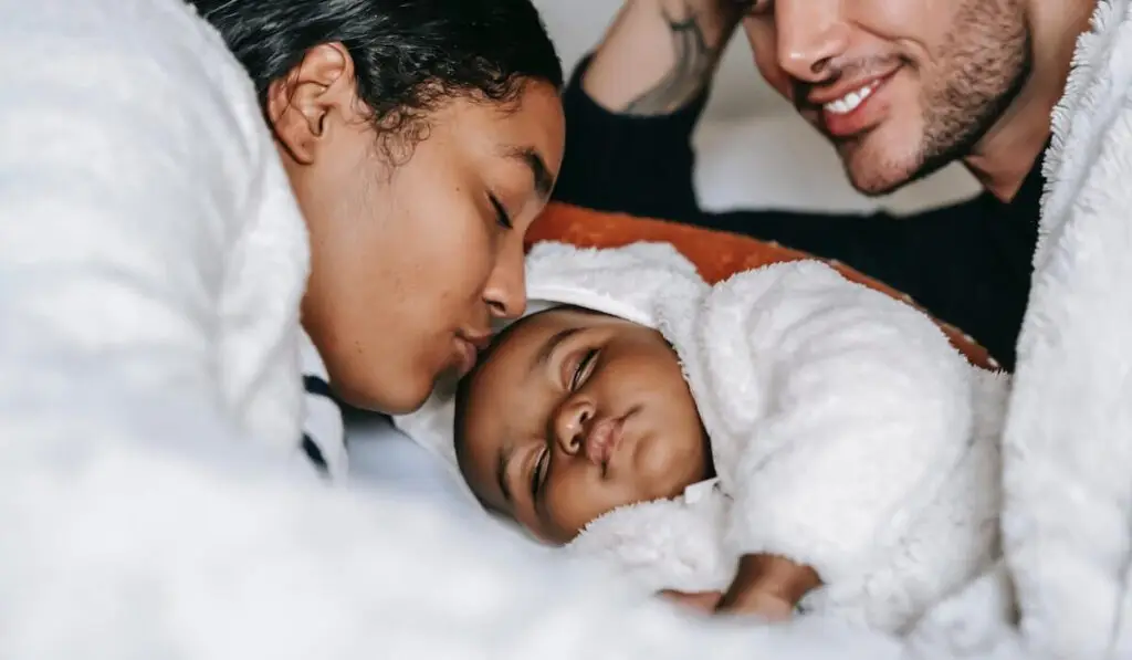 Couple kissing their baby